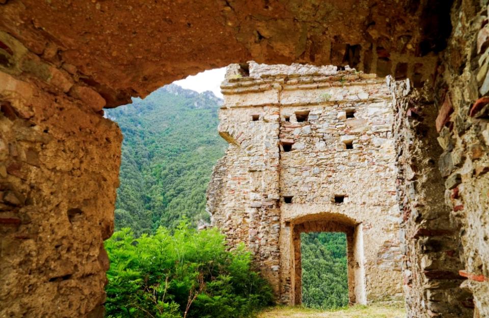 Rovine di pietra con vista su una foresta lussureggiante.